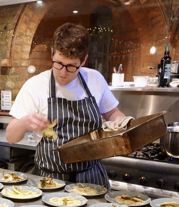 John Magee plating dishes in the kitchen